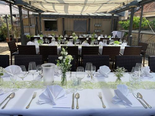 a group of tables with white table cloths and silverware at Die Kronacher Stadthotels in Kronach