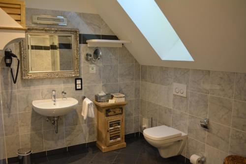 a bathroom with a sink toilet and a mirror at Die Kronacher Stadthotels in Kronach