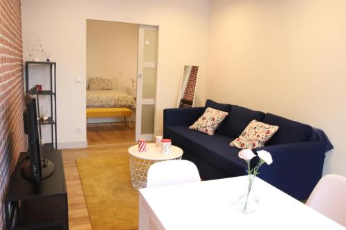 un soggiorno con un divano blu e un tavolo di COSY HOME APPART entre Paris et Disney Land a Fontenay-sous-Bois