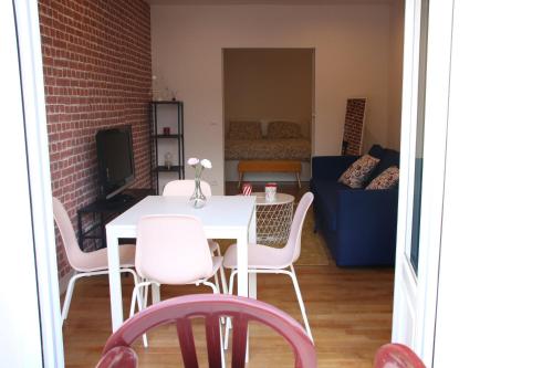 un salon avec une table et des chaises blanches dans l'établissement COSY HOME APPART entre Paris et Disney Land, à Fontenay-sous-Bois