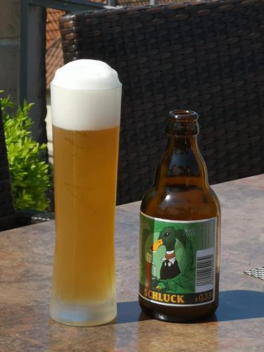 a glass of beer sitting next to a bottle of beer at Die Kronacher Stadthotels in Kronach