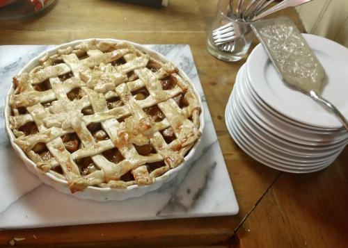 a pie sitting on top of a table with plates at Timbercliffe Cottage Inn in Camden