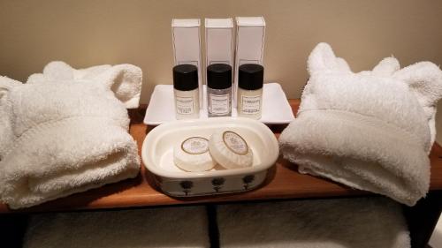 a wooden table with a tray of cosmetics and towels at Timbercliffe Cottage Inn in Camden