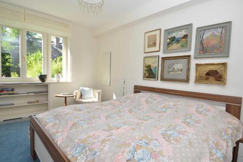 a bedroom with a large bed and some pictures on the wall at Landhaus Gernitz - Ferienwohnung Malerwinkel in Sandort