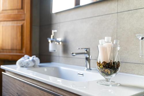 a bathroom sink with a vase with candles in it at Marcus Suite in Cagliari