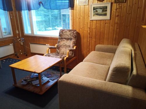 Una sala de estar con un sofá, una silla y una mesa. en Verlan Satumaa, en Verla