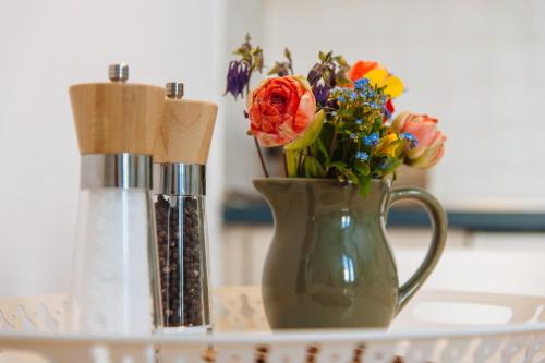 a green vase with flowers in it on a table at Apartmenthaus Kaiser Friedrich in Potsdam