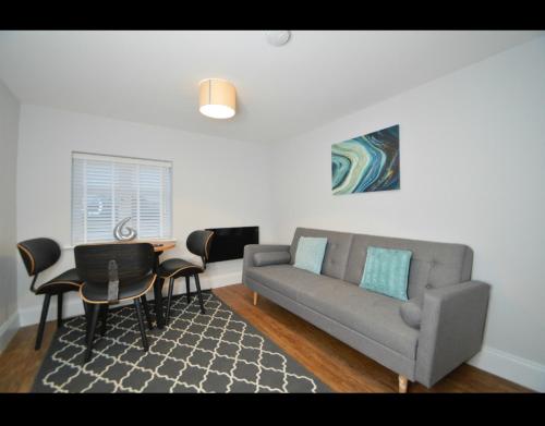 a living room with a couch and a table and chairs at The Plough Retreat in Coddington