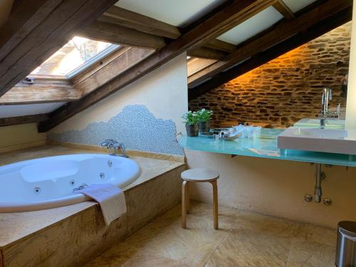 een badkamer met een groot bad en een wastafel bij Posada Real La Carteria in Puebla de Sanabria