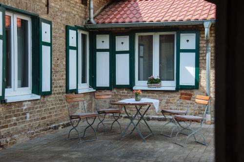 a table and chairs in front of a building with windows at Apartmenthaus Kaiser Friedrich in Potsdam