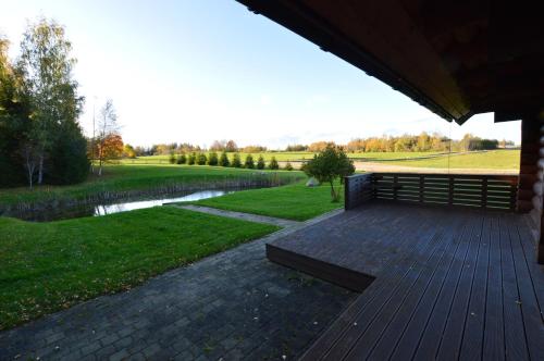 a wooden deck with a bench and a pond at RosenHausen Puhkemajad in Puugi