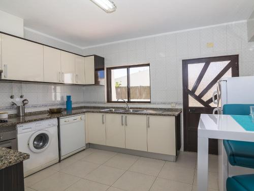 a kitchen with white cabinets and a washer and dryer at Villa Galé 600m from the beach by Interhome in Patroves