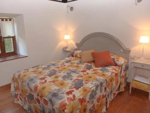 a bedroom with a bed with a floral comforter at Holiday Home Uxaneko-errota by Interhome in Bera