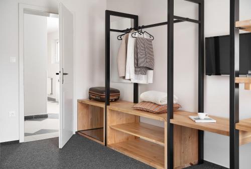 "ハルカーニャ"にあるHotel Arborétumの木製の棚とテレビが付いたクローゼットのある部屋