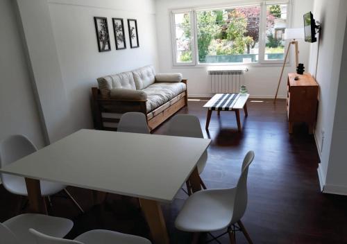 sala de estar con sofá, mesa y sillas en Departamento en el centro de Bariloche tb en San Carlos de Bariloche