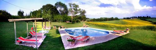 un grupo de sillas y una piscina en un patio en Agriturismo Fattoria Santa Vittoria, en Pozzo