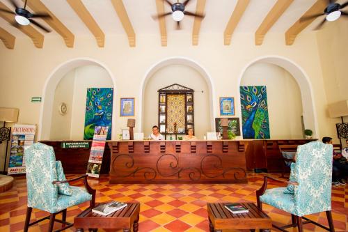 a salon with two chairs and a woman in a mirror at Hotel Merida in Mérida