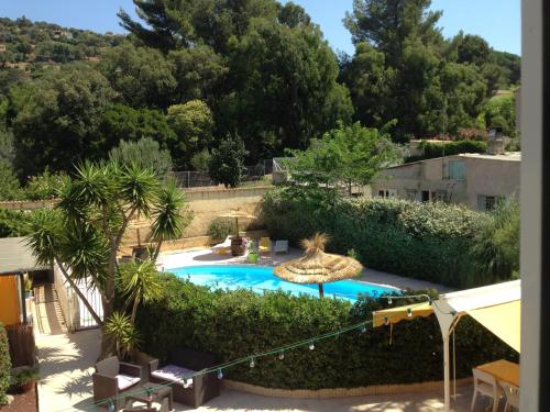 - une vue sur la piscine bordée d'arbres dans l'établissement Hôtel Les Mimosas, à Bormes-les-Mimosas