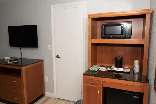 a hotel room with a microwave and a television at The Minuteman Inn Acton Concord Littleton in Acton