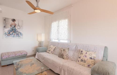 a living room with a couch and a ceiling fan at Unter den Linden in Comarruga