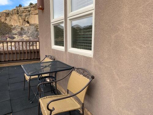 a table and two chairs on a porch with a table and a window at Slot Canyons Inn Bed & Breakfast in Escalante