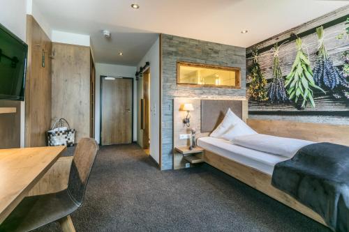 a bedroom with a bed and a table at Hotel Restaurant Krone & Wellness - Schopfheim in Schopfheim