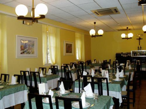 une salle à manger avec des tables et des chaises vertes dans l'établissement Hôtel Royal, à Lourdes