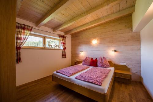 ein Schlafzimmer mit einem Bett in einem Holzzimmer in der Unterkunft Ferienwohnung Thurn-ummerstall in Hollersbach im Pinzgau