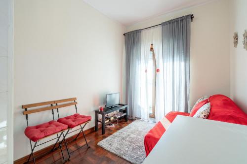 a living room with a red couch and a tv at Cozy Apartment Alegria Balcony in Porto