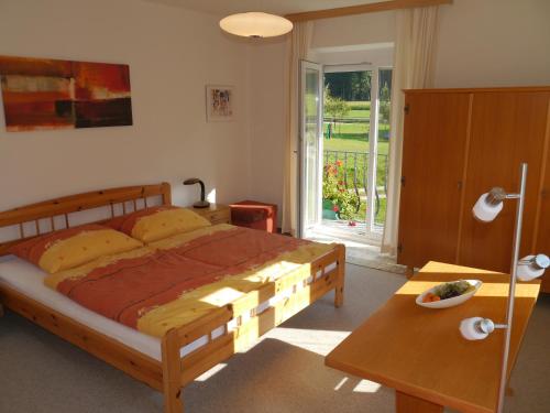 a bedroom with a large bed and a table at Haus zur Klamm in Berg im Drautal