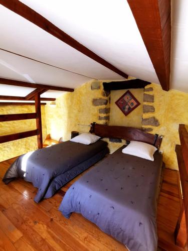 two twin beds in a room with a wall at L'Aghjalle in Santa-Reparata-di-Balagna