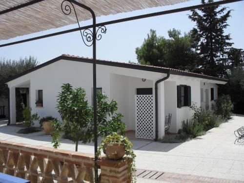 a white house with plants in front of it at Hotel Giardino Giamperduto in Bernalda