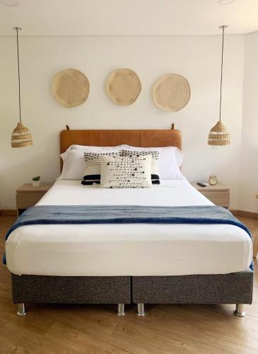 a bedroom with a large bed with three baskets on the wall at 574 Hotel in Medellín