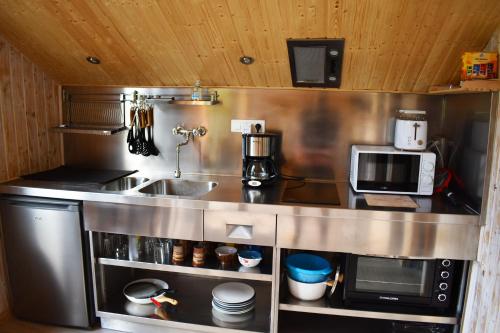 una cocina con fregadero y microondas en "La vieille Grange", au coeur de la nature, en Laveline-du-Houx