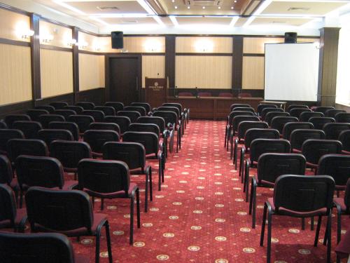 a lecture hall with chairs and a white screen at Hotel Rostov in Pleven