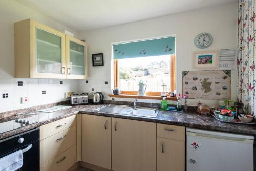 a kitchen with a sink and a window at towerhill in Culloden