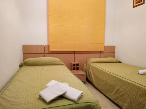 zwei Betten in einem Zimmer mit Handtüchern darauf in der Unterkunft Apartamentos Coral - Marfil Marina Dor 3000 in Oropesa del Mar