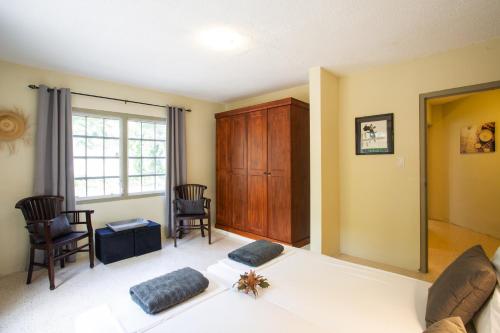 a room with a bed and chairs and a window at B&B Sombre di Kabana in Willemstad