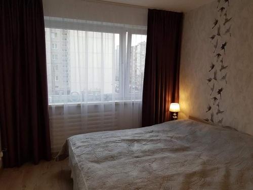 a bedroom with a bed and a large window at Cosy home 10 min from city center in Tallinn