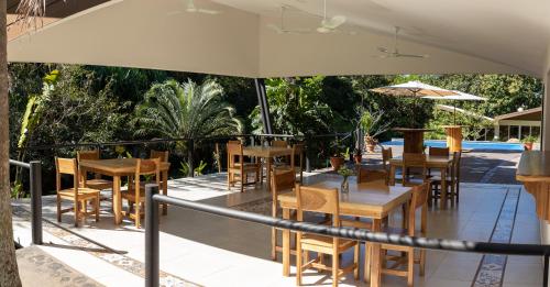 a restaurant with tables and chairs and an umbrella at Guácima Escondida Hotel Boutique in Guácima