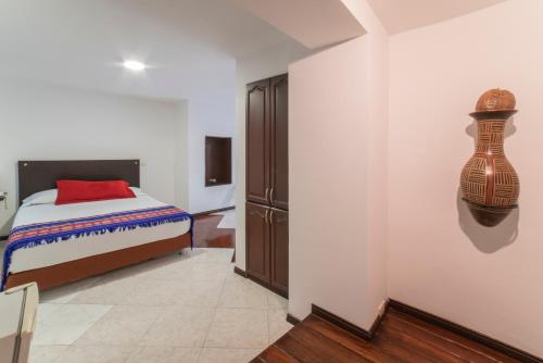 a bedroom with a bed and a vase on the wall at Ayenda Apartamento Turistico Distrito 9 90 in Cali