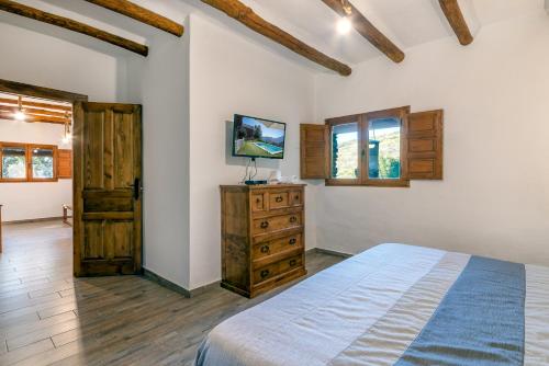 1 dormitorio con 1 cama, vestidor y ventanas en Dreams Alpujarra, en Pampaneira