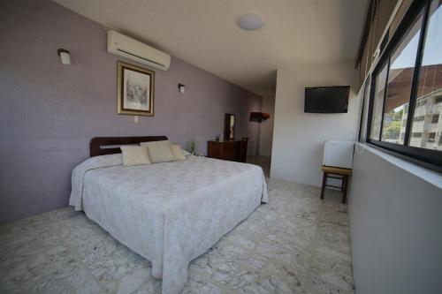 a bedroom with a bed and a large window at Hotel Plaza in Tuxpan de Rodríguez Cano