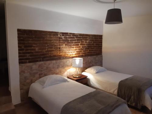 a hotel room with two beds and a brick wall at Casa Azul in Avis