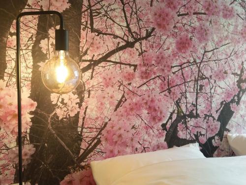 a bedroom with a pink cherry blossom wallpaper at B&B Tantine in Retie