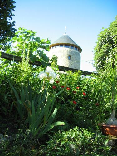 a building with a tower in the middle of a garden at Au Moulin Géant in Rochefort-sur-Loire