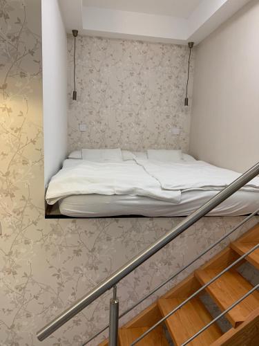 a bed in a small room with a staircase at W19 Apartments in Miskolc