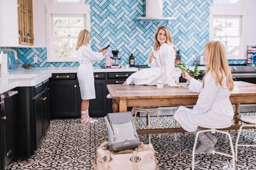 a group of three women sitting in a kitchen at The Frenchie in Round Top