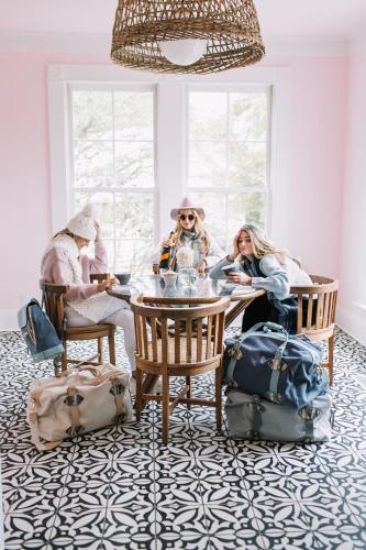 a group of people sitting around a table with luggage at The Frenchie in Round Top