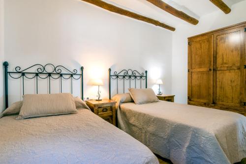 two beds sitting next to each other in a bedroom at Dreams Alpujarra in Pampaneira